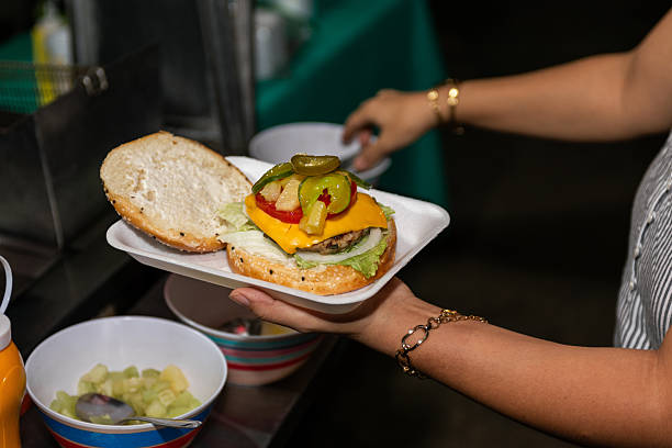 istock Hand-held burger being assembled with pineapple topping 2217142051