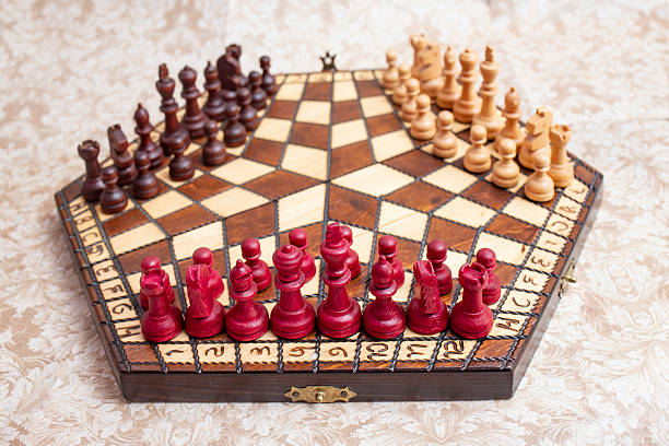 istock Three player chess board with black, white and red color pieces, on hexagonal shaped wooden board 2217143328