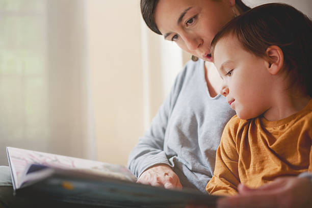 istock Toddler resting head on mother’s shoulder while reading together 2217143902