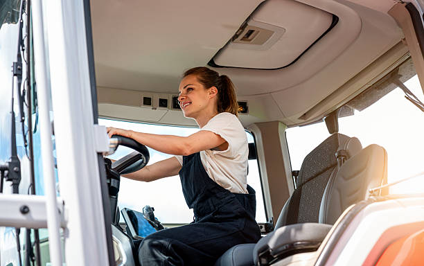 istock Confident female farm worker operating tractor. 2217144322