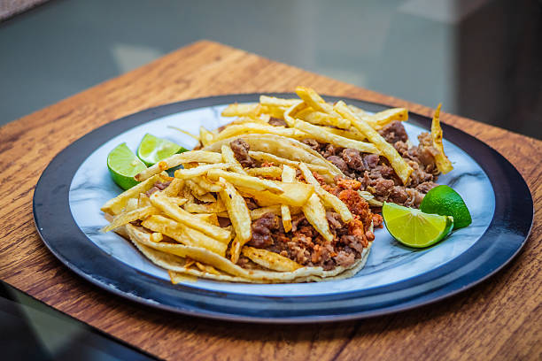 Mexican beef jerky tacos with fries on top and lemons on the side, tacos from Mexico City and Mexico State, edomex