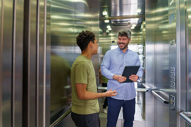 istock Latin american businessmen talking while riding in elevator 2217144854