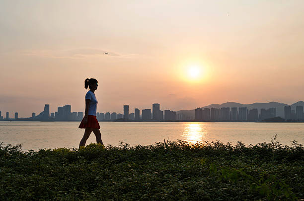 istock Woman walking on beach in sunset 2217144996