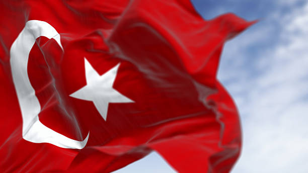 Close-up of Turkish national flag waving in the wind on a clear day. Red flag with white crescent and a star. 3D illustration render. Fluttering fabric. Selective focus