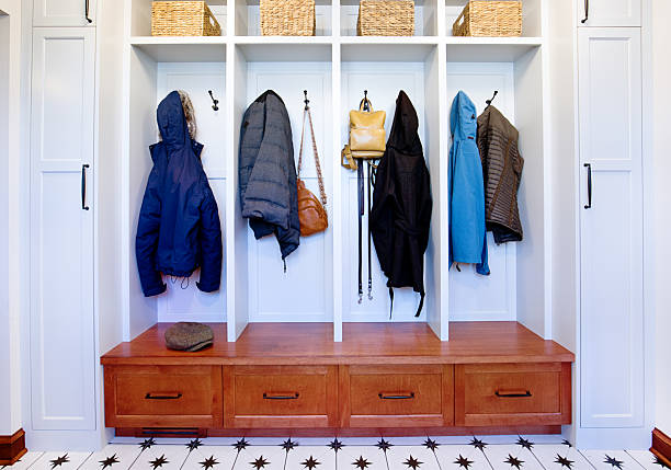 The entry wall of a residential home, a mudroom where coats are stores, a place to put on shoes and general storage and closets