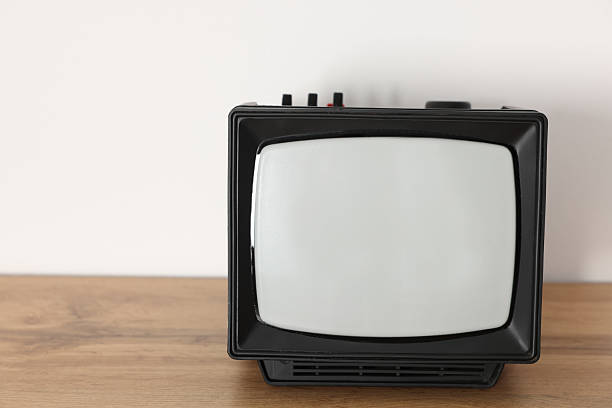 istock Retro tv set on wooden shelf against white wall. Space for text 2217150826