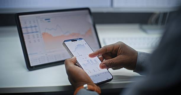 istock Stock Exchange Broker Analyzing Exchange Market Charts on Smartphone and Digital Tablet 2217151953