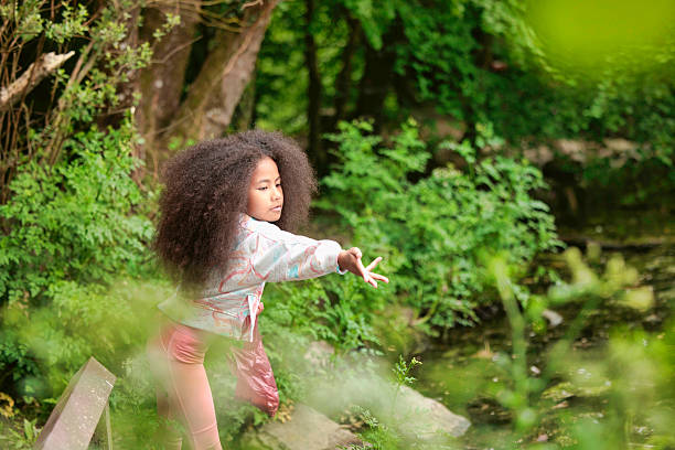 Pastel-clothed little girl helping wildlife by feeding water birds.