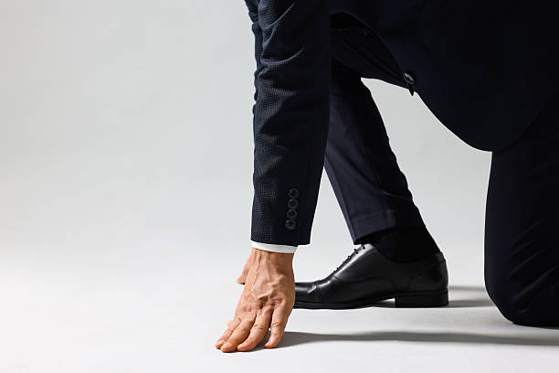 istock Businessman in starting position for run on light grey background, closeup. Space for text 2217153254