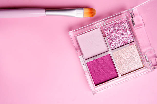 istock Pink palette of eyeshadows with brush on pink background 2217154777