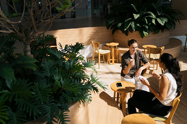 istock Two young businesswomen chatting during coffee break in modern office 2217156833