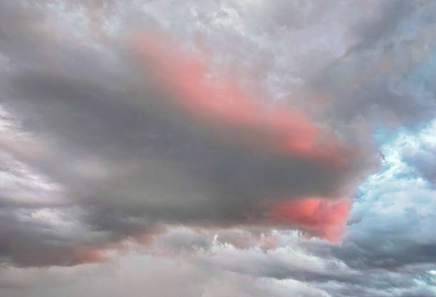 Dramatic cloudy sky in shades of gray, orange, and blue. Atmospheric, fluffy cumulus clouds, a beautiful landscape. Natural texture, background. Sunset. Full screen. Space for text with a beautiful background.
