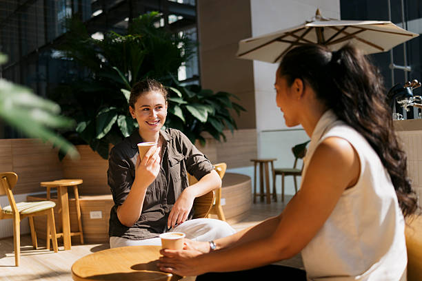 istock Two young businesswomen chatting during coffee break in modern office 2217157839