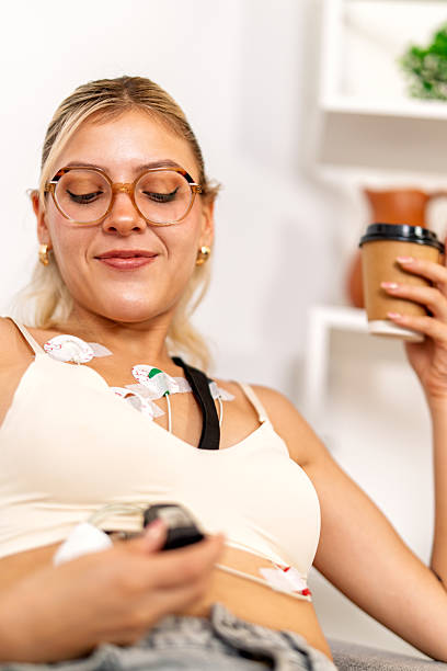istock Young woman using holter monitor at home while drinking coffee 2217158407
