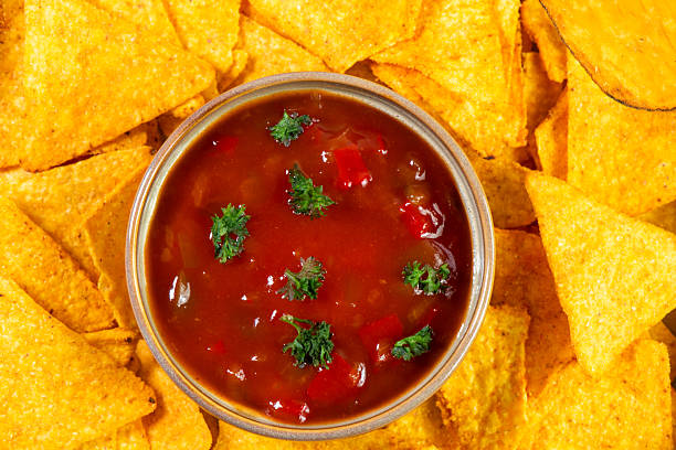 Bowl of Pico de Gallo salsa and nachos on white background.