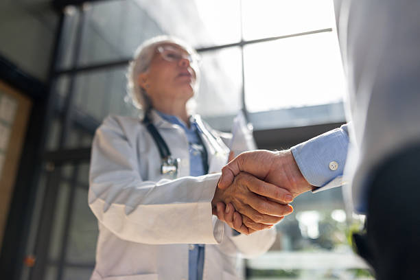 istock Two doctors greeting with a handshake at the hospital 2217159723