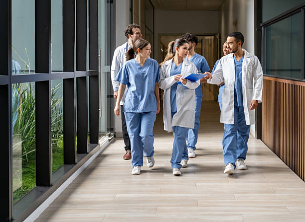 skupina studentů medicíny kráčející po chodbě nemocnice - lékař lékařské povolání - stock snímky, obrázky a fotky