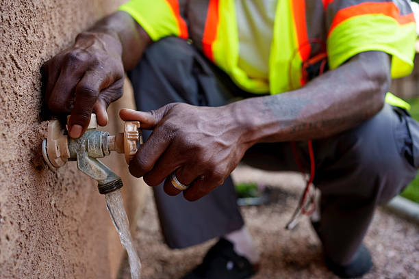 Professional Home Inspector Checking an Outdoor Water Spigot Making Sure it is Working Properly with No Leaks