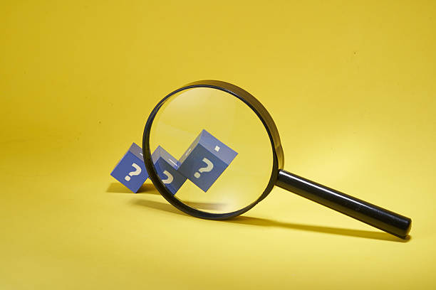 istock magnifying glass on yellow background and  cubes with question mark, information search 2217177097