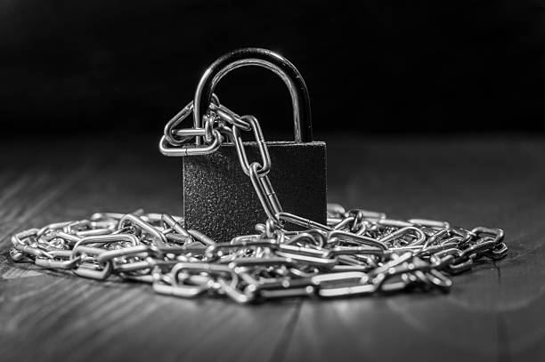istock Metal chains are tightly closed around the lock 2217177891