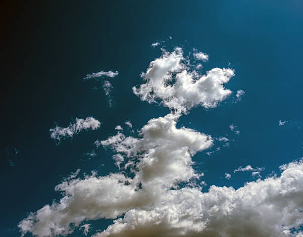 istock White cumulus clouds in a blue sky. Sepia color tones. 2217177922
