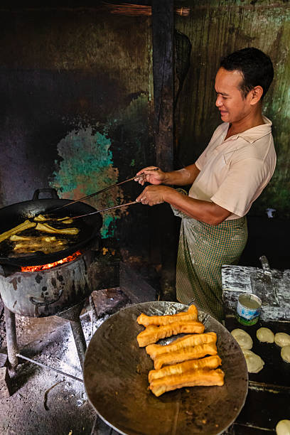 istock Burmese man preparing and selling fresh Chinese doughnuts, Myanmar 2217179415