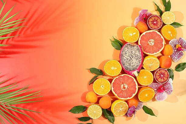 Fruity sunny banner. Summer in a snapshot, oranges, dragon fruit, apricots, pitaya, grapefruit on a bright background with shadows from a palm tree, Tropical background with exotic fruits, template for your design