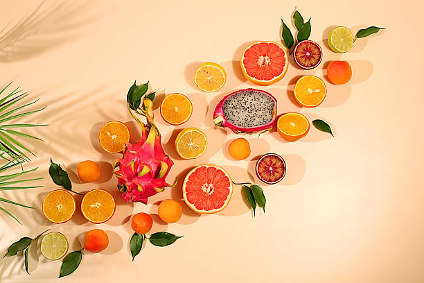 istock Fruity sunny banner. Summer in a snapshot, oranges, dragon fruit, apricots, pitaya, grapefruit on a bright background with shadows from a palm tree, Tropical background with exotic fruits, template for your design 2217181152
