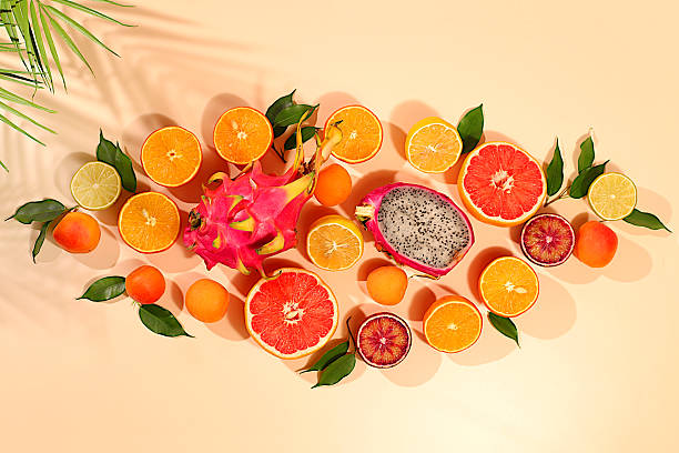 istock Fruity sunny banner. Summer in a snapshot, oranges, dragon fruit, apricots, pitaya, grapefruit on a bright background with shadows from a palm tree, Tropical background with exotic fruits, template for your design 2217181155