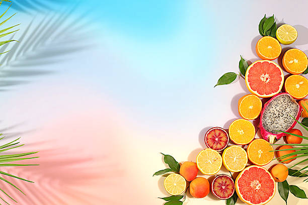 istock Summer in a snapshot, oranges, dragon fruit, apricots, pitaya, grapefruit on a bright background with shadows from a palm tree, Tropical background with exotic fruits, fruit sunny banner. template for your design 2217181168