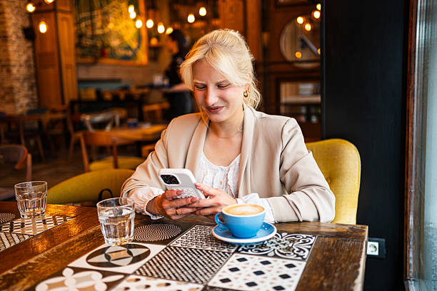 istock Young woman using smartphone in a coffee shop 2217181586