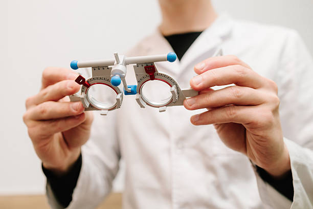 istock Trial glasses frame eye visual system of people with short or long power vision. Ophthalmologist holds trial frame glasses in hands in ophthalmology clinic. 2217183901