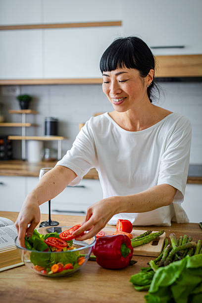 istock Woman in kitchen making salad, healthy meal 2217184697