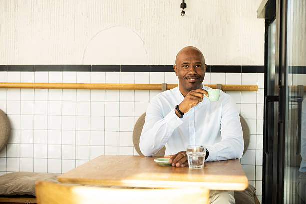 istock Smiling man drinking coffee in a modern coffee shop 2217187555