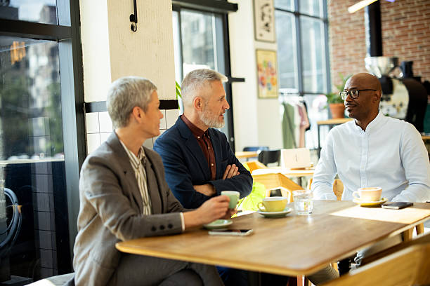 istock Business people having informal meeting while drinking coffee in cafe 2217187583