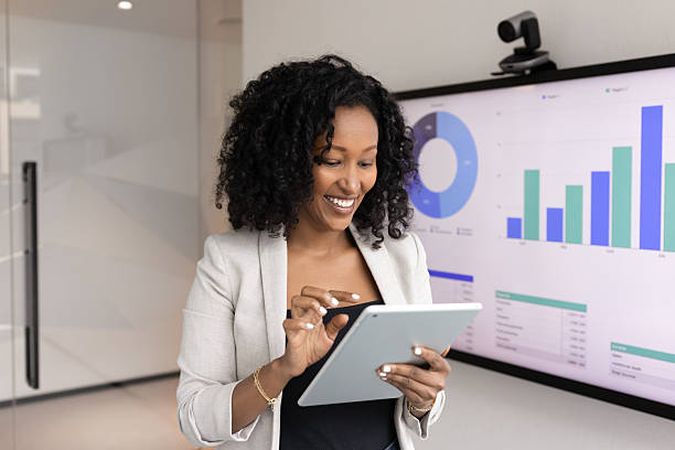 istock Smiling African woman using tablet in office 2217188255