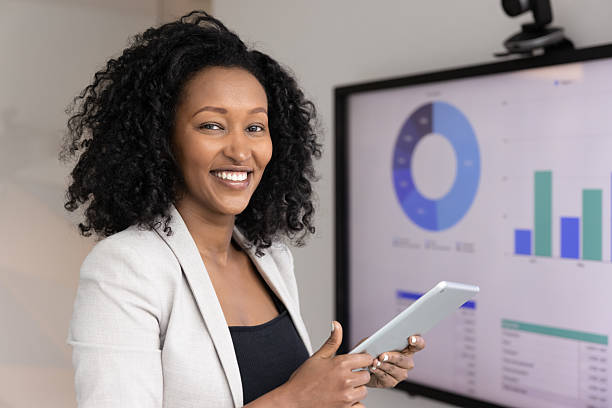 istock African female marketing analyst posing for camera with digital tablet 2217189654