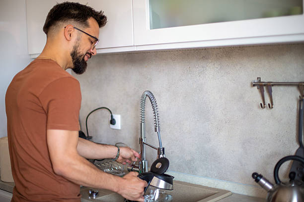 istock Man filling kettle with water in modern kitchen 2217190626