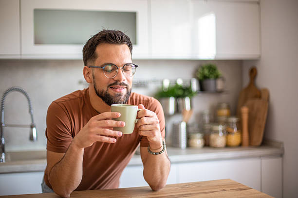 istock Young man enjoying a cup of coffee in his modern kitchen 2217191630