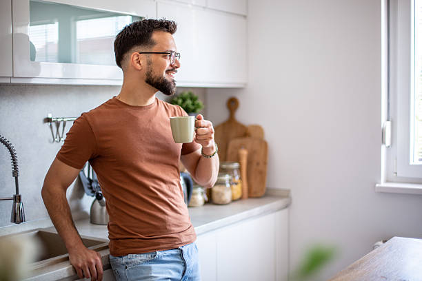 istock Young man enjoying a cup of coffee in modern kitchen 2217191687