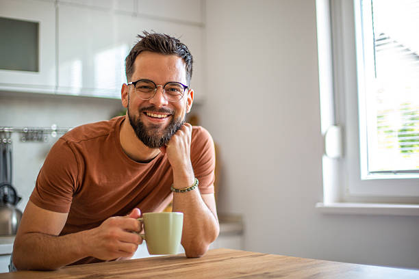 istock Happy man smiling and drinking coffee in kitchen 2217191952