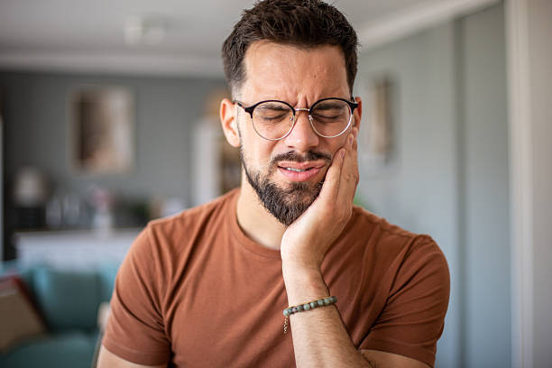 istock Young man suffering from strong toothache at home 2217192546