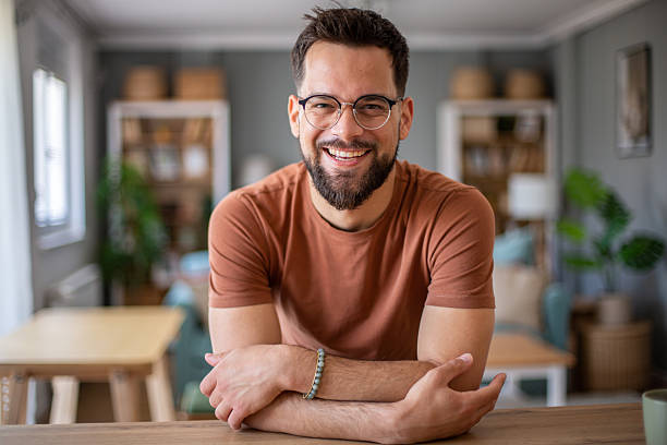 istock Young man smiling at home with folded arms 2217192562
