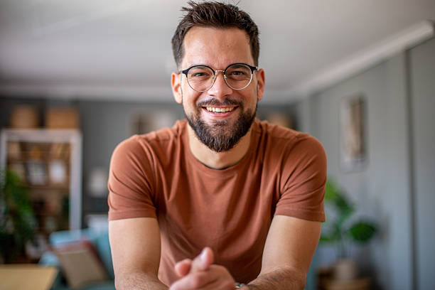 istock Young bearded man with glasses smiling at home 2217193108