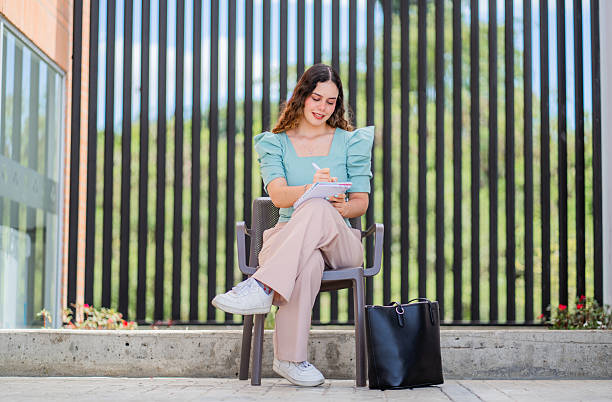 istock Young professional woman writing in a notebook while working outdoors. 2217193388