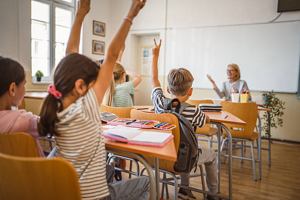 istock school kids raise hand to answer a question during a lesson 2217194651