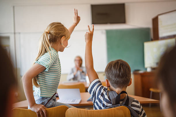 istock school kids raise hand to answer a question during a lesson 2217194818