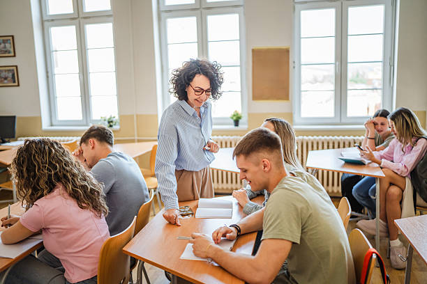 istock Female teacher help high school students do exercises in classroom 2217195286