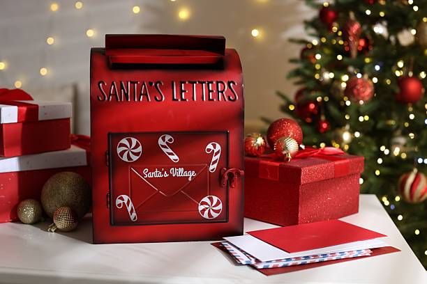 istock Santa Claus mailbox, letters, gift boxes and Christmas decor on white table indoors 2217198561