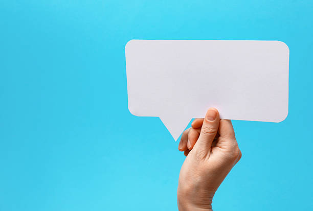 istock Woman holding blank speech bubble on light blue background, closeup. Space for text 2217198729